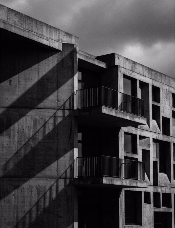 Concrete facade with diagonal shadows, high-contrast black and white